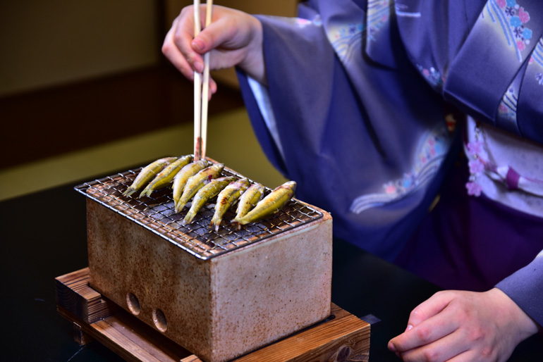 Honmoroko is grilled over charcoal by a waitress