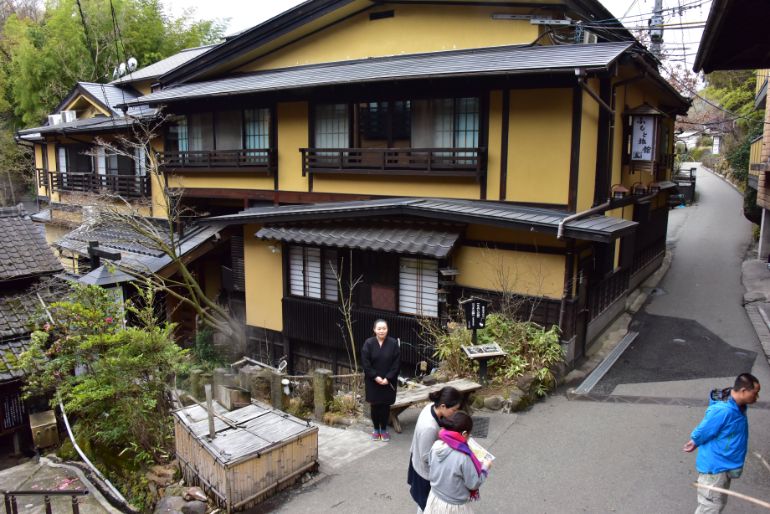 姉妹館「ふもと旅館」と道に立つ若女将